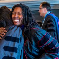 Faculty hugging one another